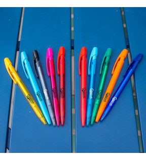 Plusieurs stylos bille sur une table bleue