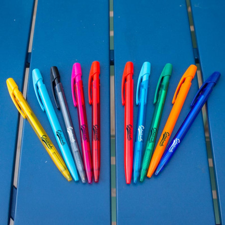 Plusieurs stylos bille sur une table bleue